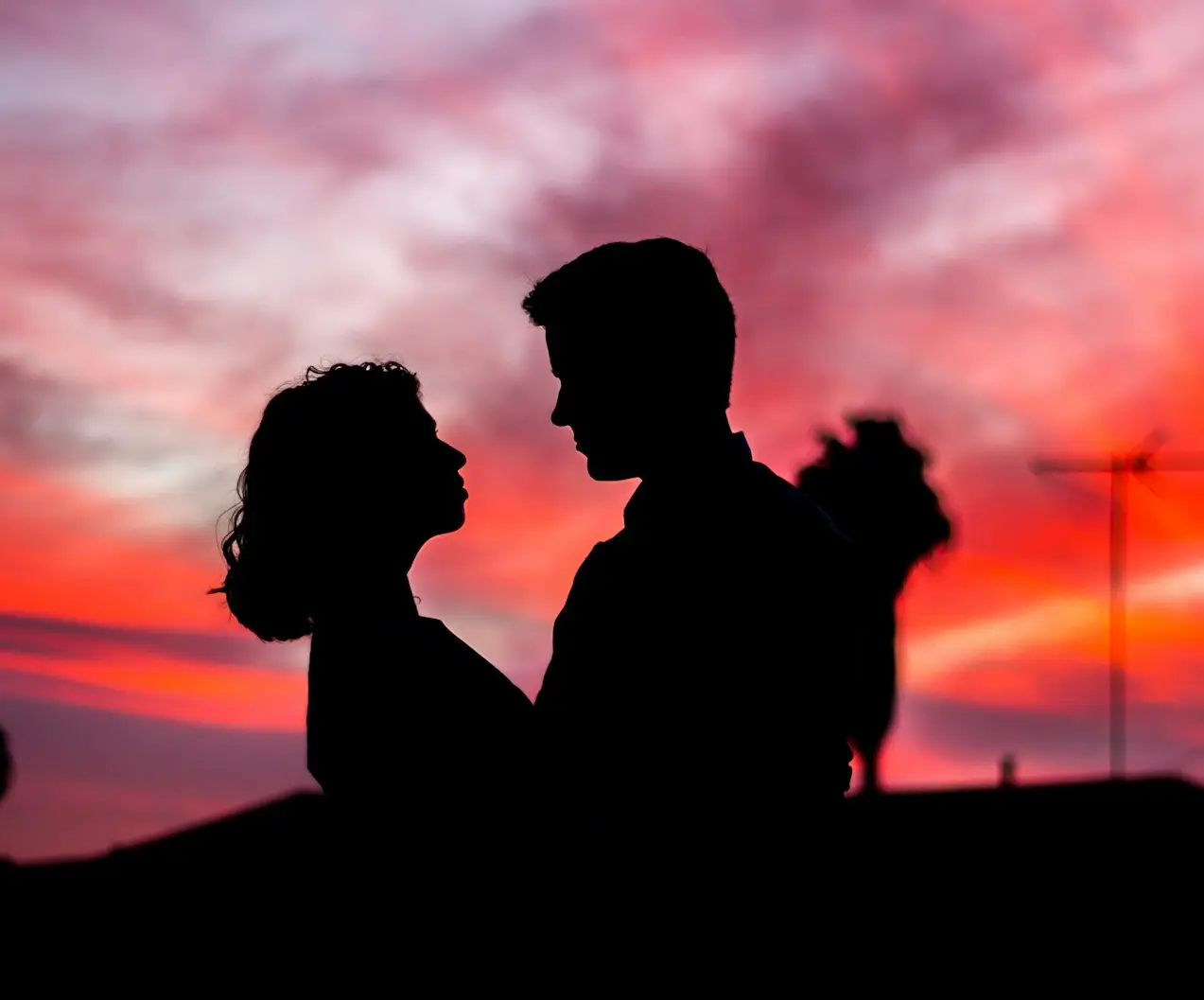 silhouette of man and woman facing each other during golden hour