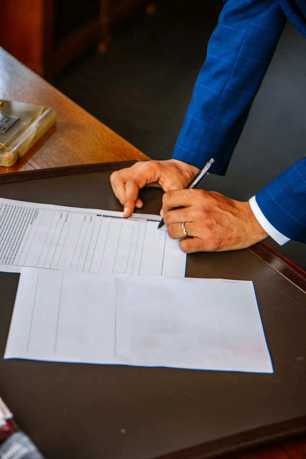person writing on white form paper